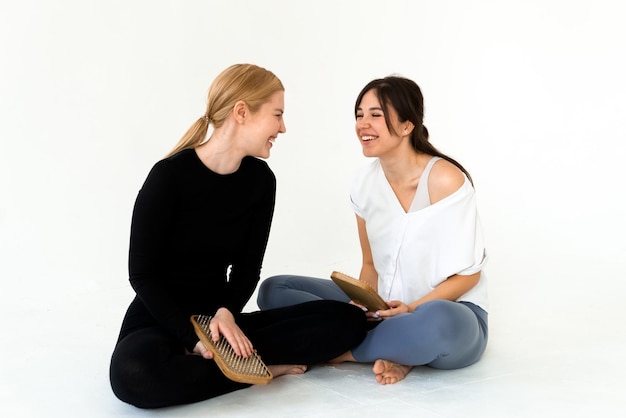 Twee meisjes die een sportuniform dragen met een sadhu-bord na de training