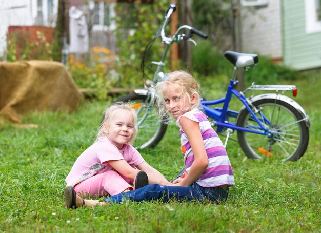 Twee meisjes die op het groene gras spelen