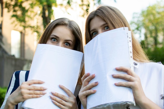 Twee meisjes gaan naar school met documenten in hun handen, studenten leren lessen