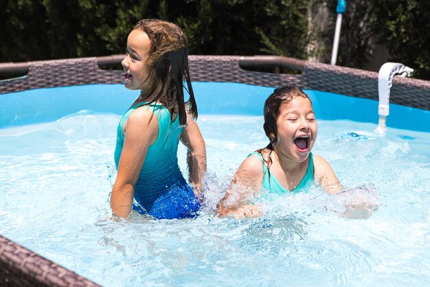 Twee meisjes in een zwembad genieten van zichzelf in het water Zwembadzwempak kinderen zomer ontspannen vakantieoord en reisconcept