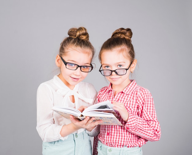 Foto twee meisjes in glazen die zich met boek bevinden