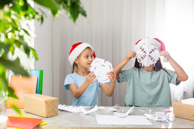 twee meisjes knippen sneeuwvlokken voor kerst