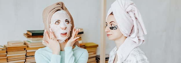 Twee meisjes maken maskers en patches voor de schoonheid van gezicht en haar