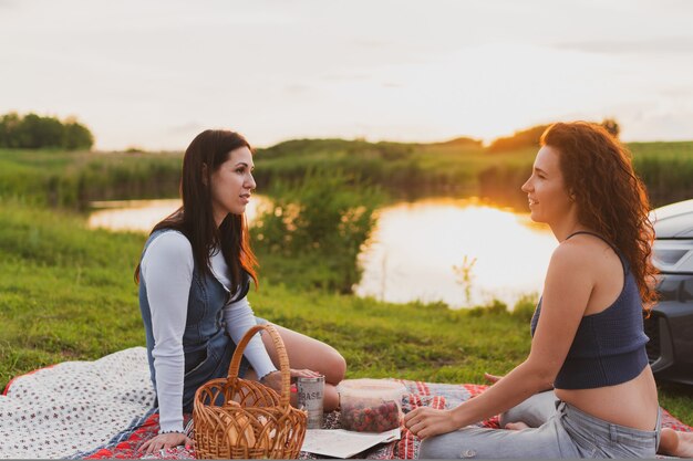 Twee meisjes rijden met de auto over de weg en zijn gestopt voor een picknick langs de weg