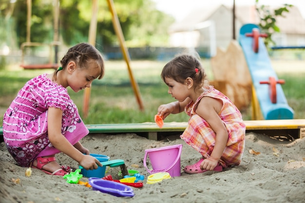 Twee meisjes spelen in de zandbak op de speelplaats