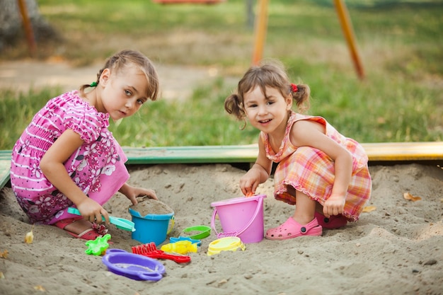 Twee meisjes spelen in de zandbak op de speelplaats