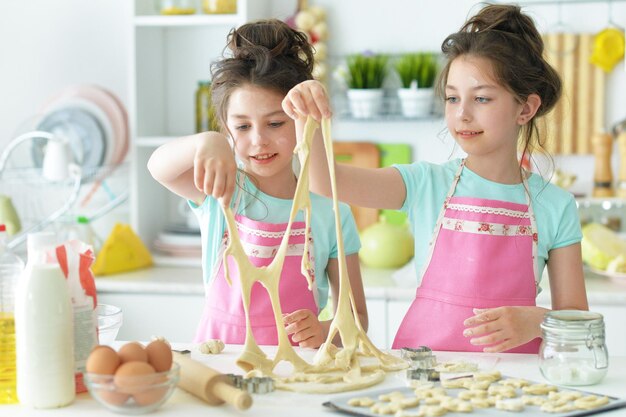 Twee meisjes zussen in de keuken koken