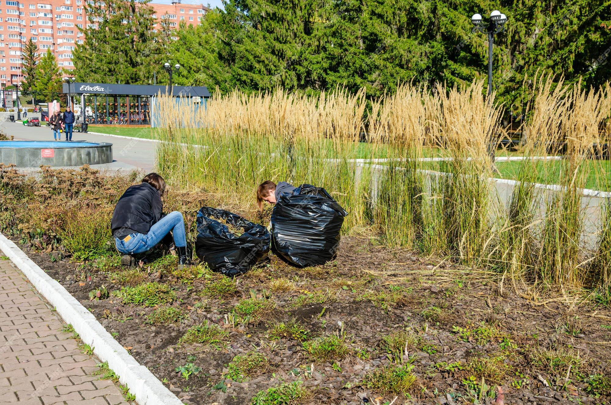 tarief Buitengewoon compressie Twee mensen aan het werk in een tuin met zakken vol onkruid | Premium Foto