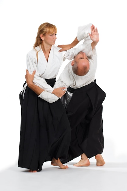 Twee mensen een man en een vrouw beoefenen aikido op de mat Geïsoleerd op witte achtergrond