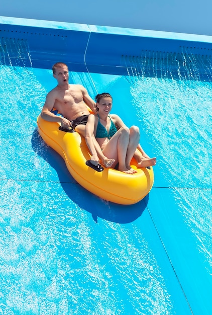 Twee mensen in een waterglijbaan op het strand