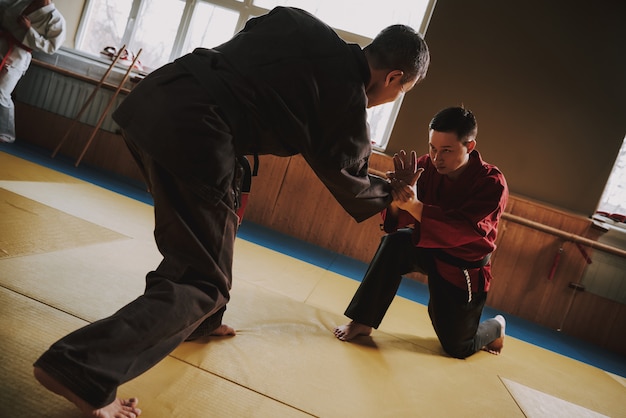 Foto twee mensen vechtsportenjagers in zwarte en rode kimono.