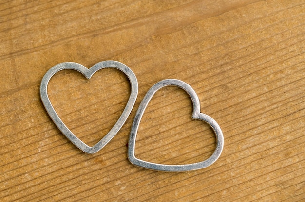 Twee metalen hartjes op een houten tafel
