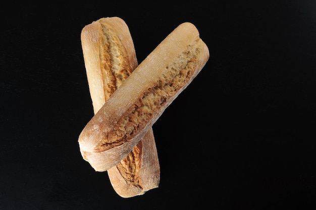 Twee mini baguettes op een zwarte achtergrond - Franse keuken - bovenaanzicht plat lag