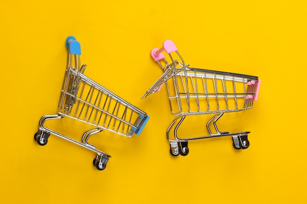 Twee mini supermarktkarretjes op geel
