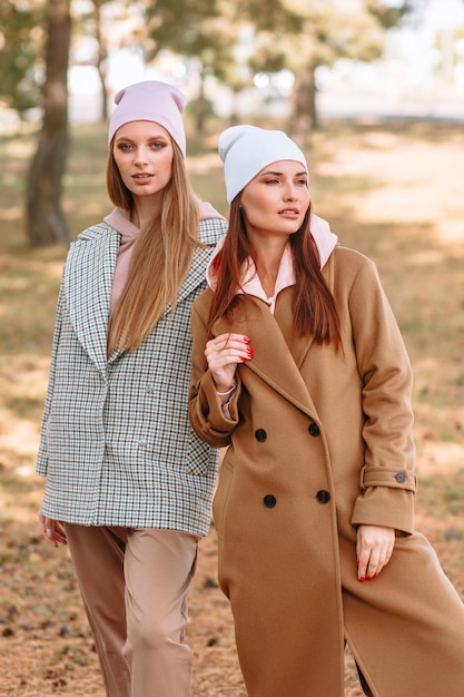 Foto twee modelmeisjes die modieuze buitensportkleding op straat laten zien kleren uit de showroom