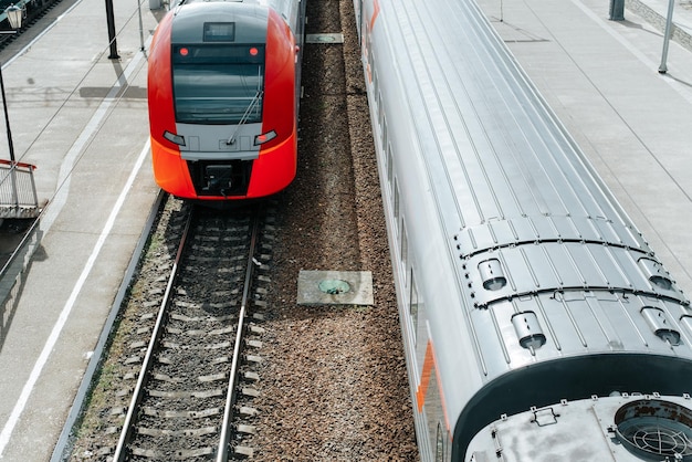 Twee moderne hogesnelheidstreinen voor passagiers rijden op rails op het treinstation buiten bovenaanzicht