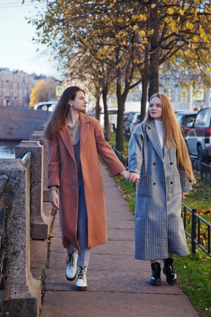 Twee modieuze jonge mooie stijlvolle vrouw in vacht lopen op straat