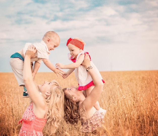 Twee moeders met kinderen in veld