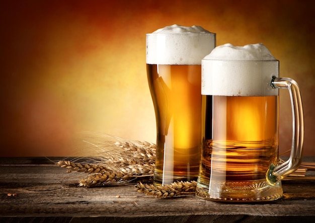 Foto twee mokken bier en tarwe op een houten tafel