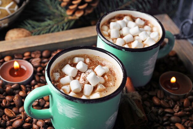 Twee mokken warme cacao met marshmallow op koffiebonen