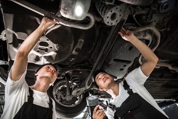 Foto twee monteurs controleerden de auto-ophanging.