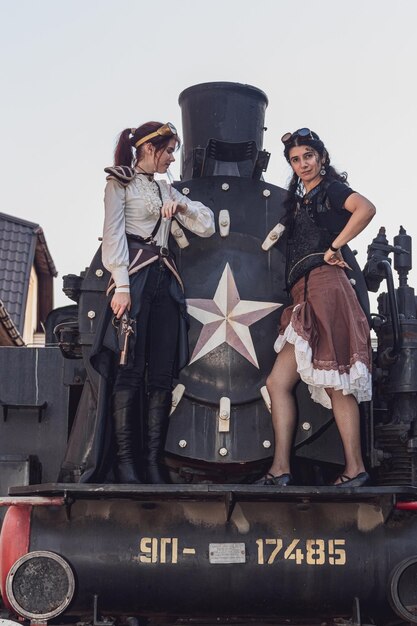 Twee mooi meisje in steampunk kleding op de achtergrond van de trein