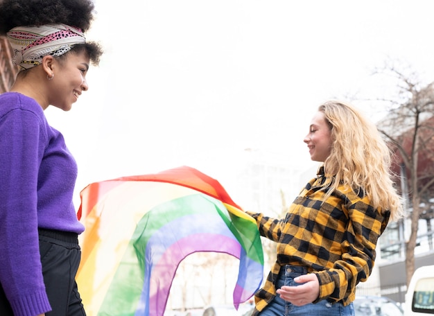 Foto twee mooie afrikaanse en blanke vrouwen, met gay pride-vlag