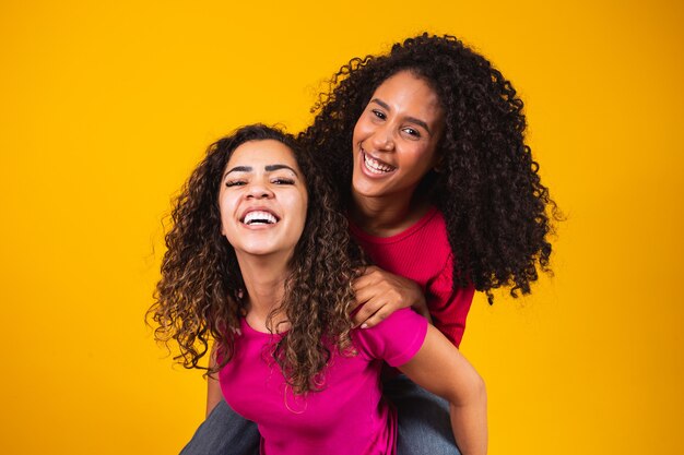 Twee mooie afro-vrienden omhelsde, concept van beste vrienden en zussen.