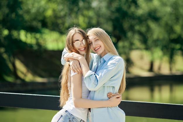 Twee mooie jonge vrouwen die elkaar omhelzen