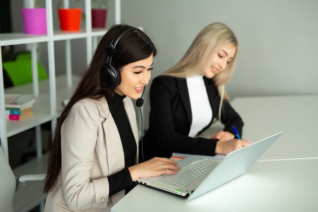 twee mooie jonge vrouwen op kantoor met een laptop