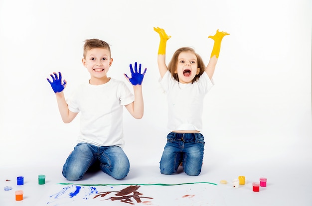 Twee mooie jongen en meisje van kindvrienden tekenen foto's met verf