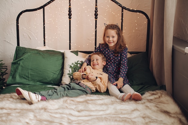 Twee mooie kinderen zitten samen op het bed