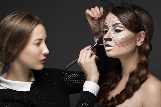 Twee mooie meisjes op fotoshoot om gezichtsmake-up toe te passen Beauty fashion model