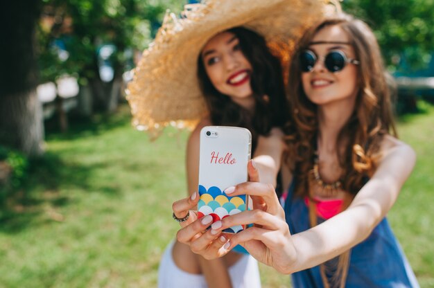 Twee mooie meisjeshippie om selfie dichtbij oude boot te maken