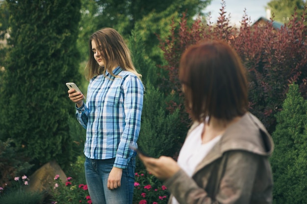 Twee mooie schattige tieners deelt geheimen roddels Verrassing gezicht emoties Beste vrienden dragen stijlvolle outfit zwarte hoed zonnebril jurk heldere lente kleuren