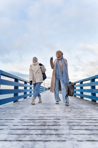 Twee moslimvrouwen lopen op de peer tijdens het reizen