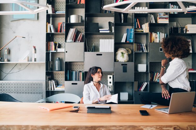 Twee multiraciale studenten die een project bespreken in een co-working kantoor