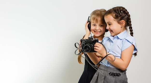 Twee nieuwsgierige vriendelijke schoolmeisjes kijken naar foto's tijdens de pauze