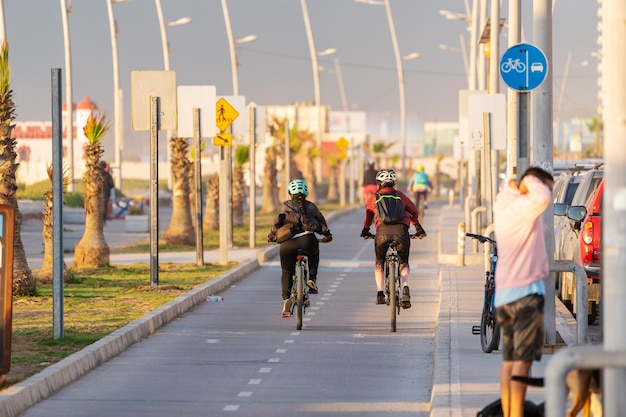 twee onbekende Latijns-vrouw op een fiets op een fietspad bij prachtige zonsondergang in La Serena Chile