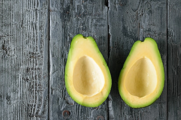 Twee ontpit avocado helften op een zwarte tafel