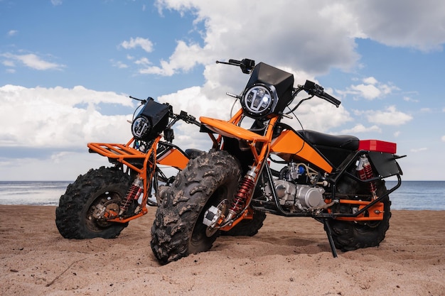 Twee op maat gemaakte offroad-sportmotoren staan buiten op het strand geparkeerd