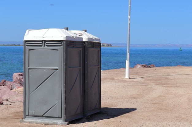 Twee openbare toiletten in grijze kleur op een strand