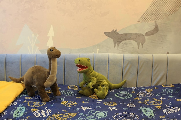 Twee opgezette dinosaurussen op het kinderbed.