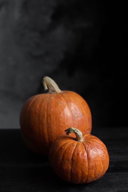 Twee oranje pompoenen op een zwarte achtergrond