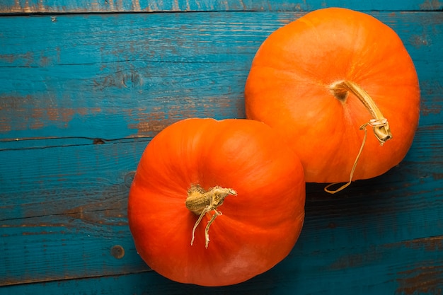 Twee oranje pompoenen op oude blauwe houten achtergrond