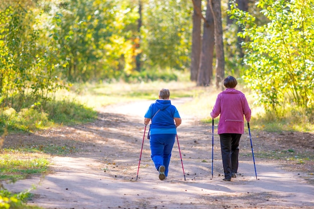 Twee oudere vrouwen doen een scandinavische wandeling