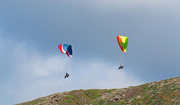 Twee paragliders vliegen op een bewolkte dag