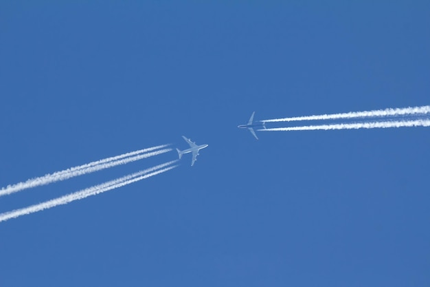 Twee passagiersvliegtuigen vliegen naar elkaar in de blauwe lucht, telefoto-opname