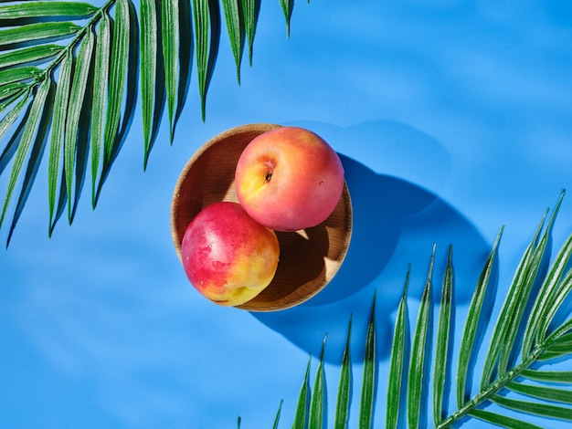 Twee perziken in een kom op tafel - bovenaanzicht