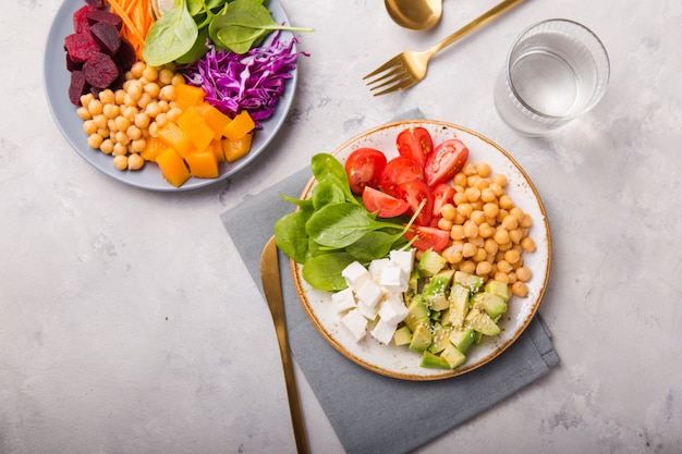 Twee platen Boeddha Kommen en glas water. Concept voor gezonde vegetarische detox evenwichtige maaltijd. Bovenaanzicht Kopieer ruimte.